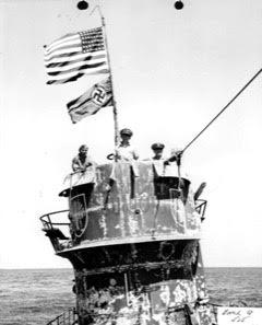 All Aboard! <br />Commander Trosino, Captain Gallery and Lieutenant David aboard the U-505. The United States flag is flying above the Kriegsmarine Ensign which is an international protocol to signal the enemy ship has been captured.